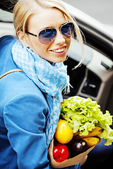 Image showing young pretty blond woman with food in bag walking on street