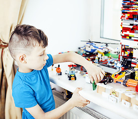 Image showing little cute preschooler boy playing lego toys at home happy smil