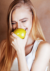 Image showing young pretty blond woman with green apple happy cheerful smiling