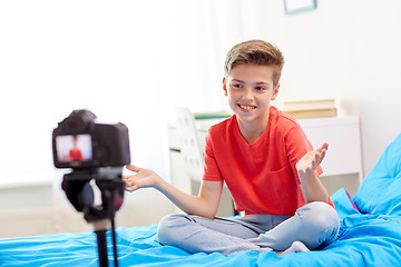 Image showing happy boy with camera recording video at home