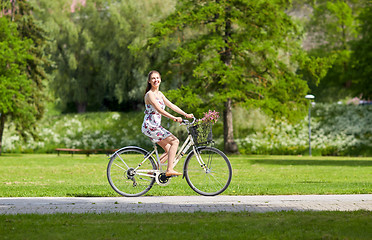 Image showing happy woman riding fixie bicycle in summer park