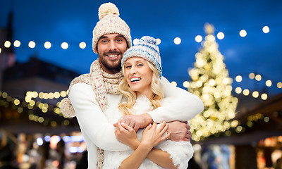 Image showing happy couple hugging over christmas tree lights