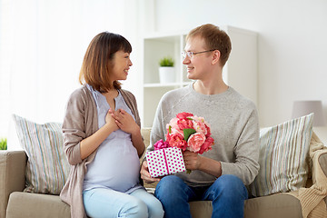 Image showing happy husband giving present to his pregnant wife