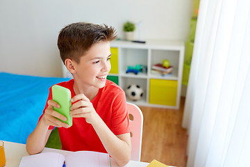 Image showing student boy with smartphone distracting from study