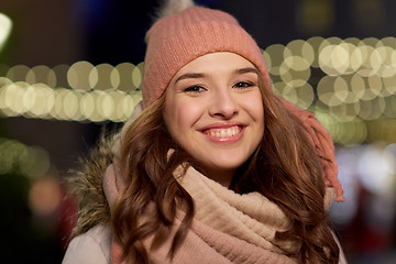 Image showing happy young woman over christmas lights in winter