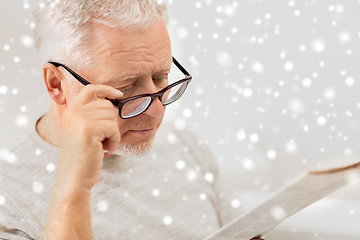 Image showing close up of old man in glasses reading newspaper