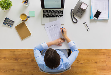 Image showing businesswoman signing contract document at office