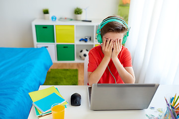 Image showing boy in headphones playing video game on laptop