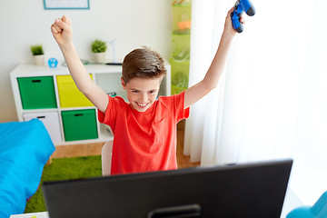 Image showing boy with gamepad playing video game on computer