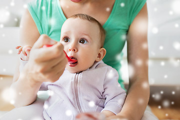 Image showing mother with spoon feeding little baby at home