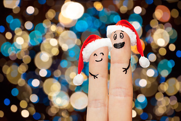 Image showing two fingers in santa hats over christmas lights