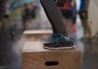 Image showing black woman is performing box jumps at gym