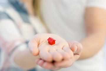 Image showing couple showing small red house in hands