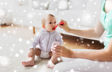 Image showing mother with spoon feeding little baby at home