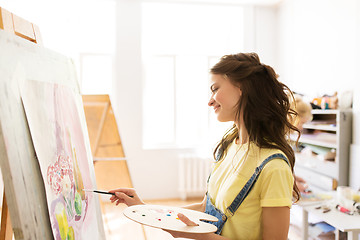 Image showing student girl with easel painting at art school