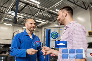 Image showing auto mechanic giving key to man at car shop