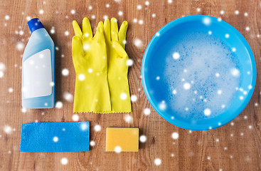 Image showing basin with cleaning stuff on wooden background