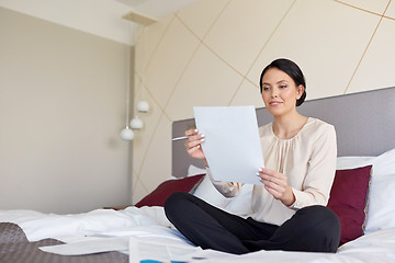 Image showing businesswoman with papers working at hotel room