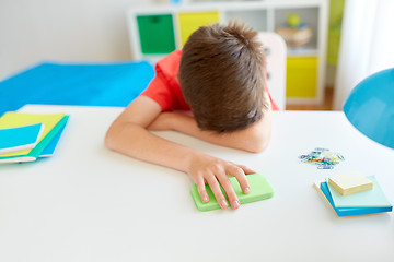 Image showing tired or sad student boy with smartphone at home