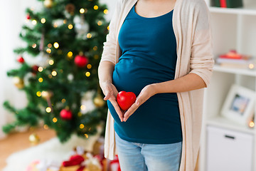 Image showing close up of pregnant woman with heart at christmas