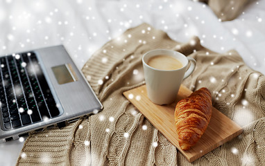 Image showing laptop, coffee and croissant on bed at cozy home