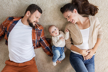 Image showing happy family with baby lying on floor at home