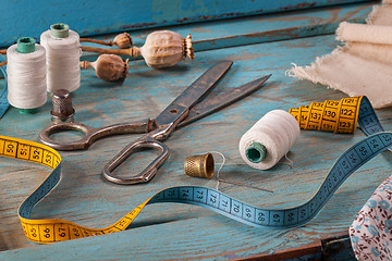 Image showing Retro sewing accessories on blue wooden background