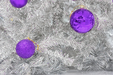 Image showing Decoration ultraviolet baubles on silver artificial Christmas tree