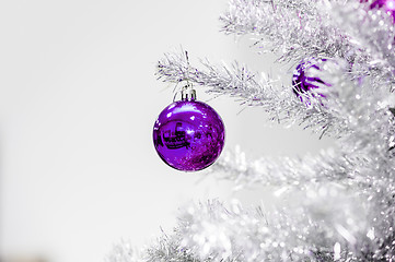 Image showing Decoration ultraviolet baubles on silver artificial Christmas tree