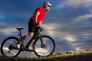 Image showing Man in helmet and glasses stay on the bicycle