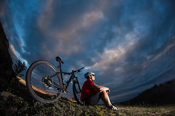 Image showing guy has a rest sitting near his bike