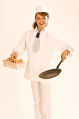 Image showing female chef with chanterelles and pan