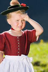 Image showing Little girl in a dress looks in the country