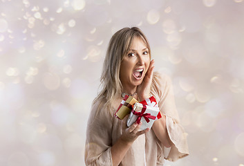 Image showing Surprised woman holding some Christmas gifts