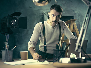 Image showing Architect working on drawing table in office