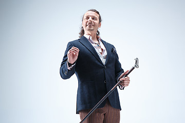 Image showing The mature barded man in a suit holding cane.