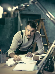 Image showing Architect working on drawing table in office