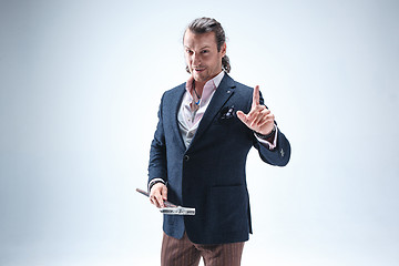 Image showing The mature barded man in a suit holding cane.