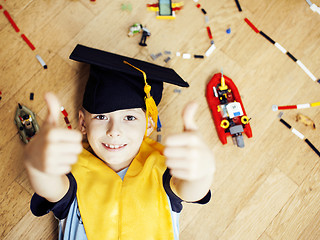 Image showing little cute preschooler boy among toys lego at home in graduate 