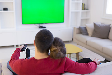 Image showing Young couple on the sofa watching television