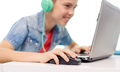 Image showing boy in headphones playing video game on laptop