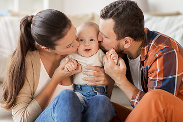 Image showing happy mother and father kissing baby at home