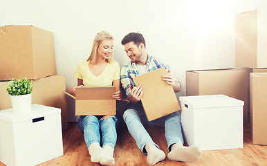 Image showing smiling couple with many boxes moving to new home