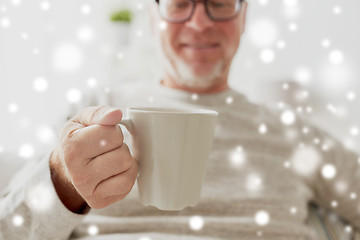 Image showing happy senior man with cup of tea or coffee at home