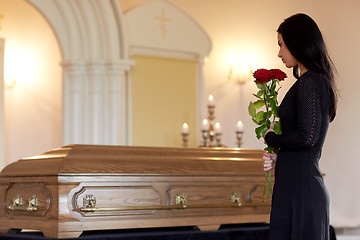 Image showing woman with red roses and coffin at funeral