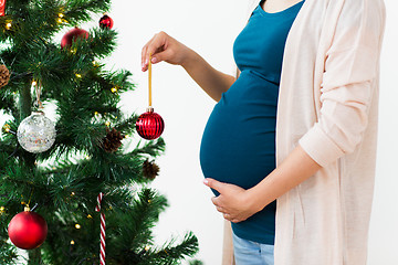 Image showing pregnant woman decorating christmas tree