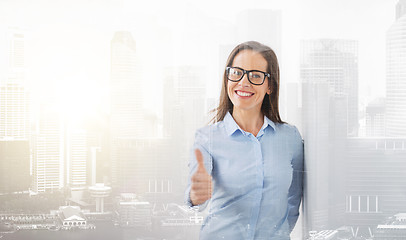 Image showing happy smiling woman in glasses showing thumbs up