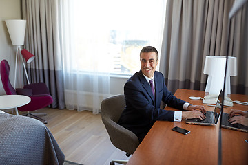 Image showing businessman typing on laptop at hotel room