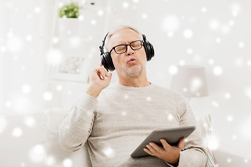 Image showing senior man with tablet pc and headphones at home