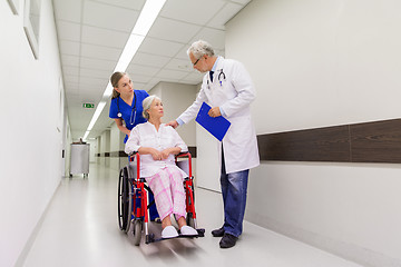 Image showing medics and senior patient in wheelchair at clinic